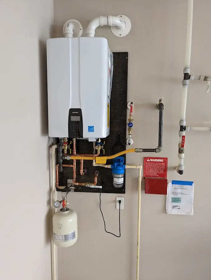 Professional plumber installing copper piping in a Danby home